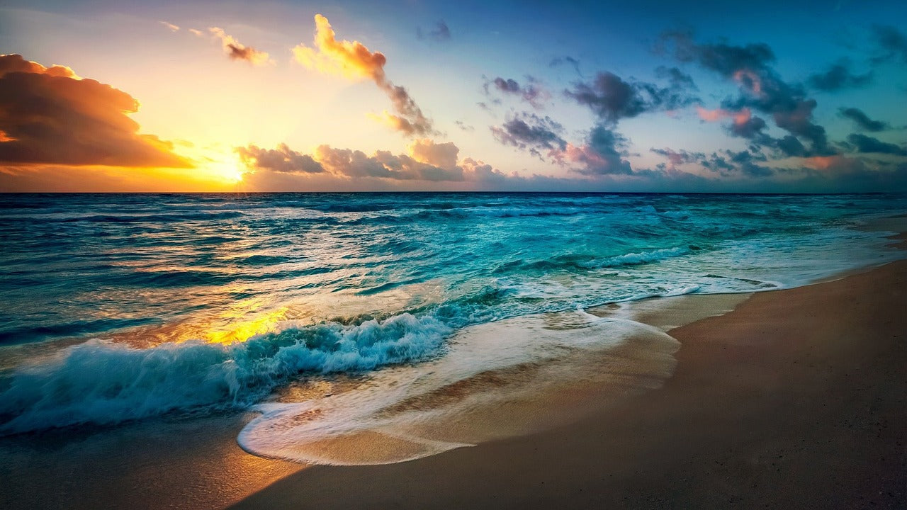 A beautiful ocean sunset photo of waves crashing on the beach